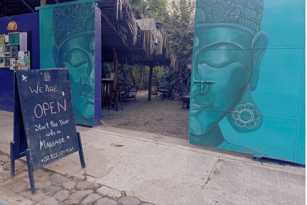green buddha mural on Doorway at El estar yoga and wellness san pancho